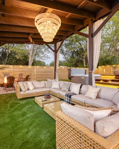 Modern home with pool, patio seating, umbrellas, and desert landscaping with cacti and mature trees
